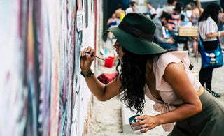 woman painting graffiti on wall - graffiti vs vandalism
