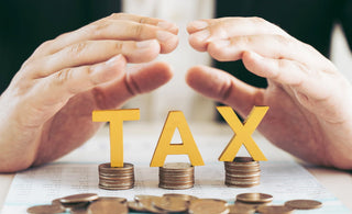 yellow words saying tax on top of coins - tax efficient investing