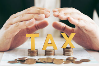 yellow words saying tax on top of coins - tax efficient investing