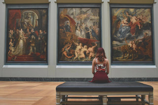 woman looking at famous paintings - top investments to make money